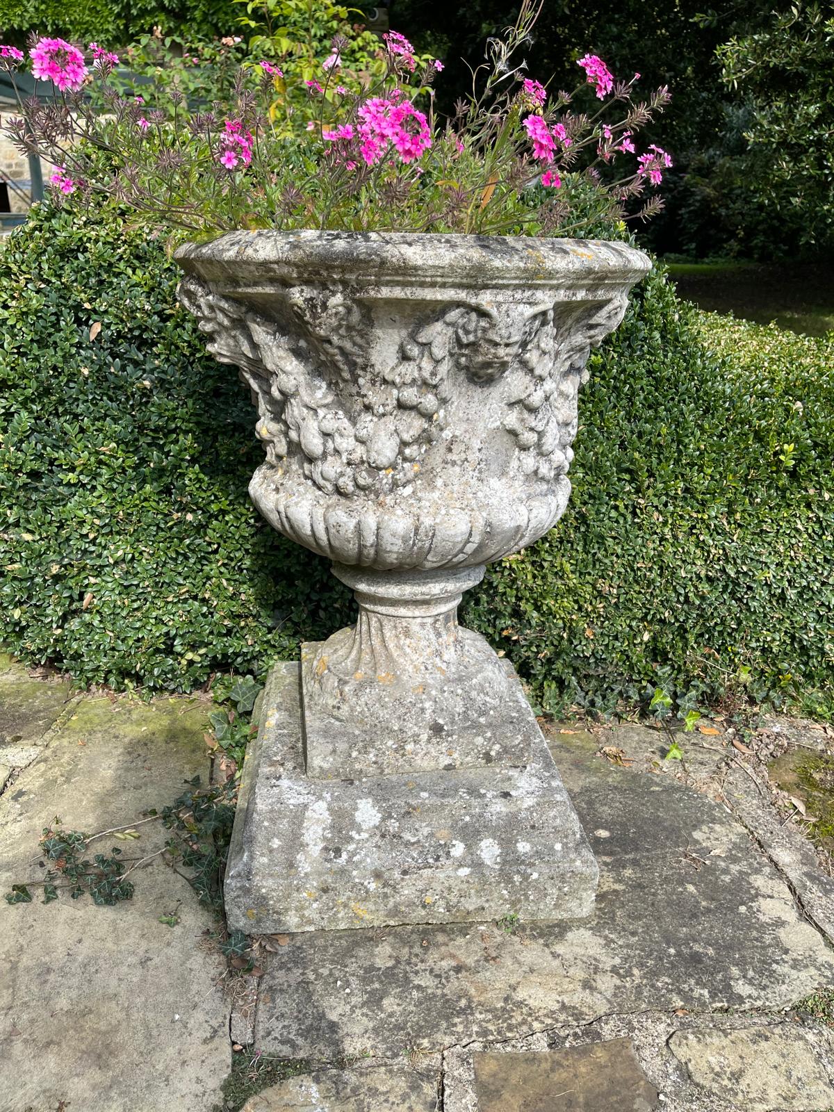 Three reconstituted stone campana shaped garden urns